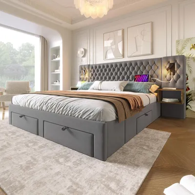 A modern bedroom with a large upholstered bed, nightstand, and a large window.