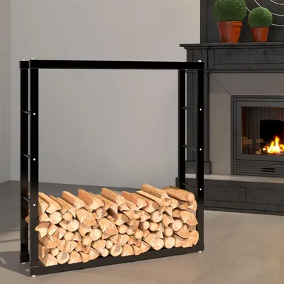 A black metal firewood rack filled with logs is placed in front of a fireplace.