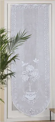 A white lace door panel with floral and bird embroidery is shown hanging in a doorway.