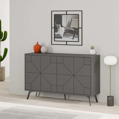 A modern living room scene featuring a grey sideboard with geometric patterns, two decorative vases, a framed picture on the wall, a floor lamp, and a potted cactus.