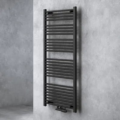 A black radiator is mounted on a textured gray wall.