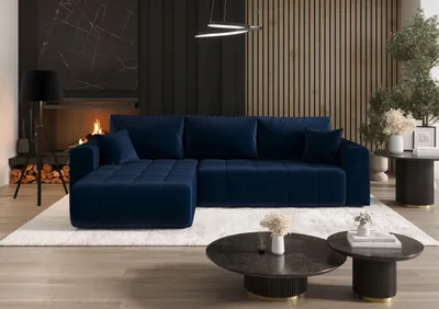 A modern living room with a navy blue sectional sofa, fireplace, and coffee tables.