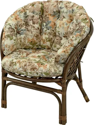 A close-up shot of a rattan armchair with floral cushions.