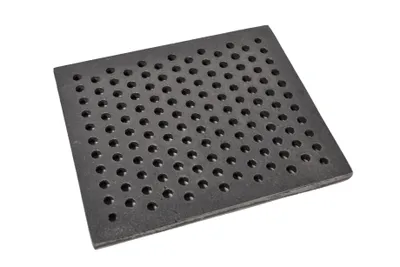 A square cast iron grate with many small holes, shown at an angle on a white background.