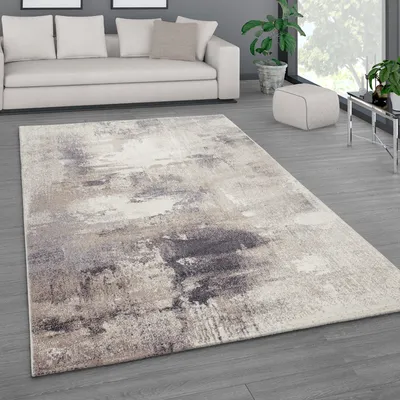 A modern living room with a sofa, rug, and plants.
