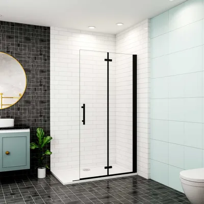 A modern bathroom with a black-framed glass shower enclosure, a vanity with a round mirror, and tiled walls and floor.
