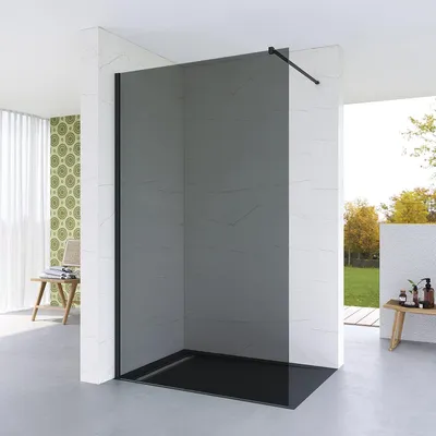 A modern bathroom with a walk-in shower, featuring a dark tinted glass enclosure and a black shower tray.