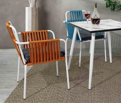 Produktbild von Originalstühle hell orange Farbe auf weißen Beinen Edelstahleinemweichen Kissen
