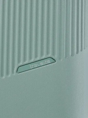 A close-up view of the textured surface of a light green suitcase, featuring the embossed 'Travelite' logo.