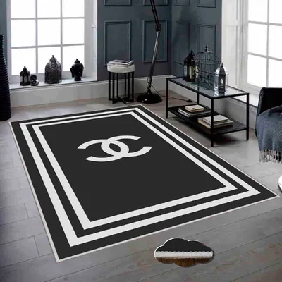 A modern living room with a black and white rug featuring a prominent logo.
