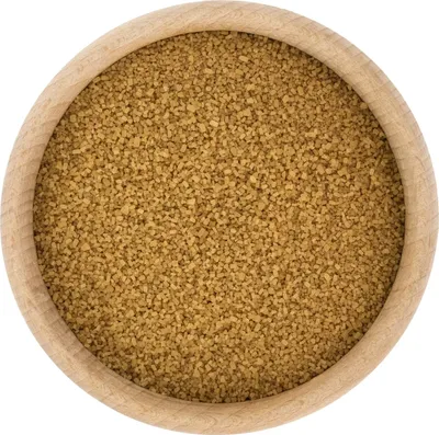 A close-up, top-down view of brown sugar in a wooden bowl.