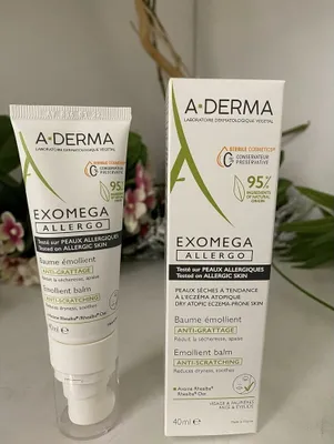 A product shot of a skincare product and its box, with some blurred foliage in the background.
