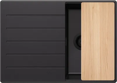 A top-down view of a black kitchen sink with a wooden cutting board placed over one section.