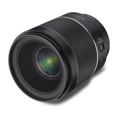 A close-up studio shot of a black camera lens against a white background.