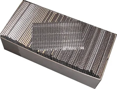A box filled with metal nails, with a small stack of nails on top.