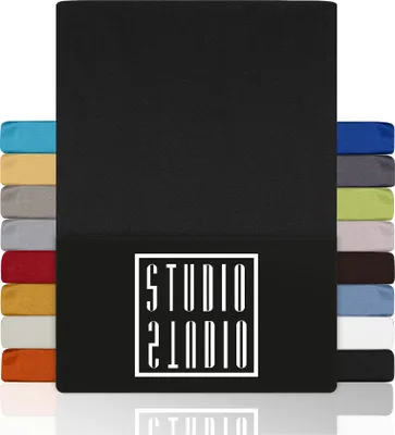 A stack of fabric swatches in various colors, with a large black swatch dominating the foreground and a logo on the lower portion.