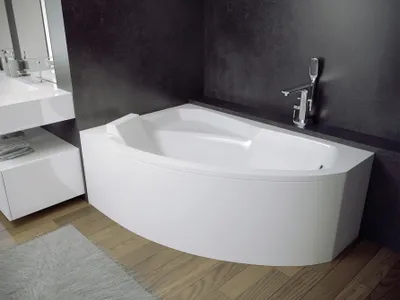 A modern bathroom with a white corner bathtub, a white vanity, and dark gray walls.