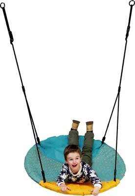 A young boy is lying on a nest swing.