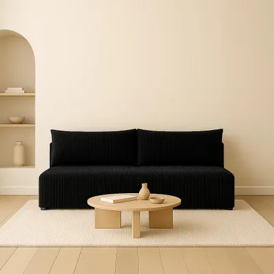 A black sofa in a minimalist living room setting with a coffee table in front of it.