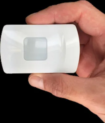 A hand holding a small white electronic device.