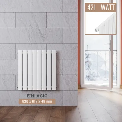 A white panel radiator mounted on a gray tiled wall, with a doorway and balcony visible in the background.