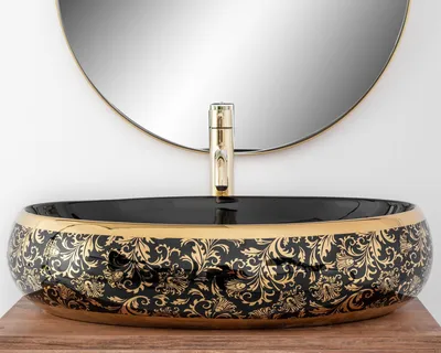 A close-up shot of a decorative washbasin with a gold faucet, set against a white background and a round mirror.