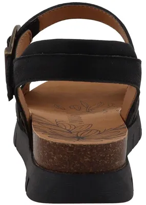 Auf dem Bild ist eine schwarze Sandale zu sehen die eine offene Vorderseite und einen gepolsterten Riemen hat. Die Ansicht zeigt die Sandale von der Seite und hebt die Form und das Design hervor.