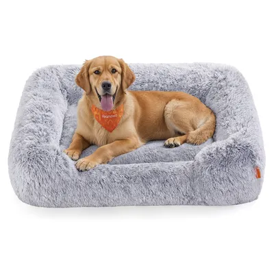 A golden retriever dog is lying on a plush gray dog bed.