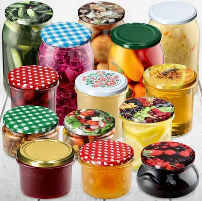 A collection of various jars filled with preserved food items, arranged on a white surface.