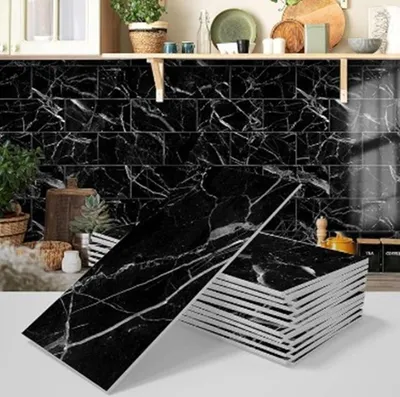 A stack of black marble-patterned tiles in the foreground, with a kitchen backsplash and countertop in the background.