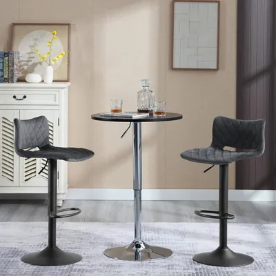 Two dark gray bar stools are positioned around a small, round, black bar table with a chrome base. The scene is set in a room with a white cabinet in the background and a framed picture on the wall.