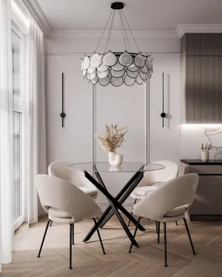 A dining room setting with a glass-top table and chairs, a chandelier, and wall sconces.