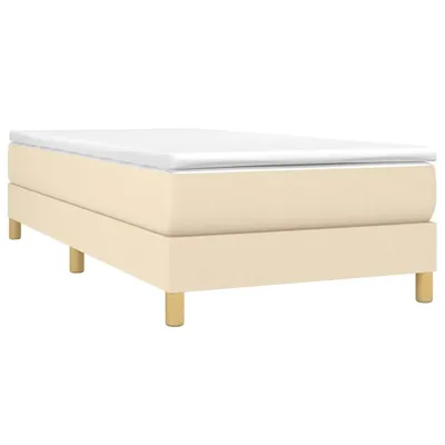 A cream-colored box spring bed frame with a white mattress topper, shown from the side on a white background.