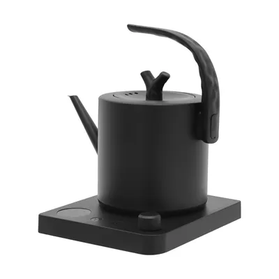 A black electric kettle with a unique handle design sits on its charging base against a white background.