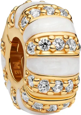 A close-up studio shot of a gold and white charm with clear stones.