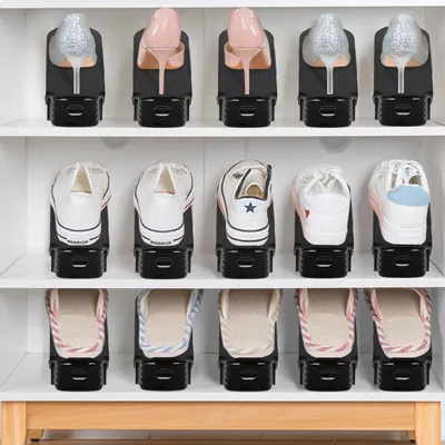 A shoe rack filled with different types of shoes organized using shoe stackers.
