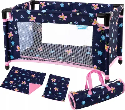 A doll's travel crib with accessories laid out around it.