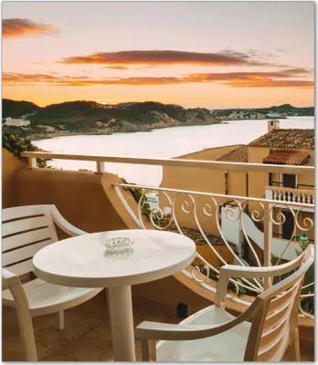 Produktbild von Wallario Herdabdeckplatte aus Glas, Größe 52 x 60 cm 1-teilig, Motiv Sommer in Spanien - Ausblick von einer schönen Terrasse auf das Meer