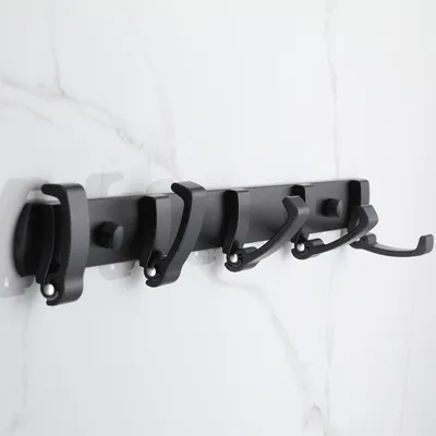 A black folding hook rack mounted on a marbled wall.