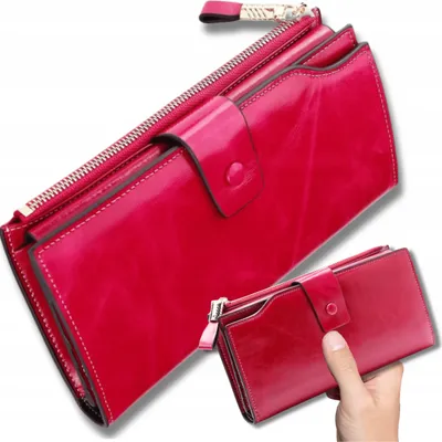 A red leather wallet is shown against a white background. A smaller version of the wallet is held in a hand.