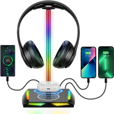 A headphone stand with integrated wireless charging and RGB lighting, displaying headphones, earbuds, and smartphones.