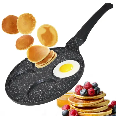 A frying pan with multiple sections for cooking pancakes and an egg, with cooked pancakes and a stack of pancakes with berries shown.