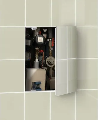 A close-up view of a hidden inspection door in a tiled wall, revealing plumbing and utility components.
