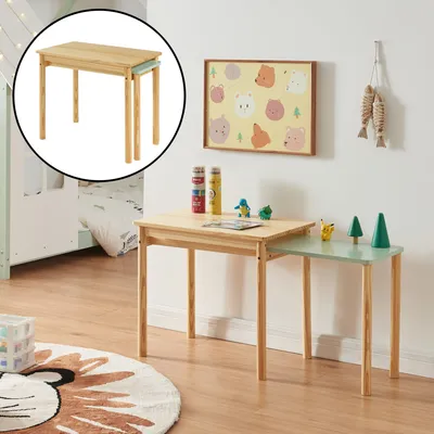 A child's room with a wooden table and chairs, a rug, and wall art.