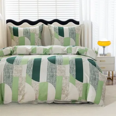 A neatly made bed with a green geometric pattern duvet cover and pillows.