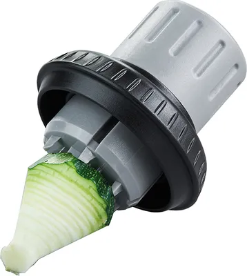 A close-up of a vegetable spiralizer attachment with a piece of zucchini being processed.