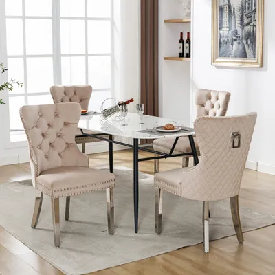 A dining room set with a marble-top table and four beige upholstered chairs.