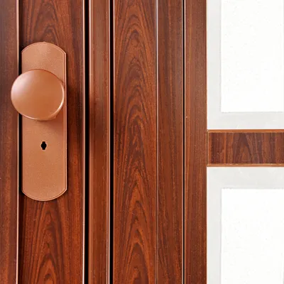 A close-up view of a wooden door with a doorknob and keyhole.