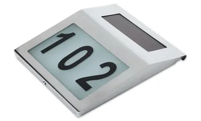 A solar-powered house number light with the number 102 illuminated.