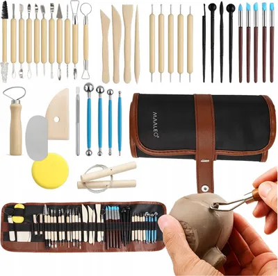 A collection of pottery sculpting tools laid out and a hand using a tool on clay.